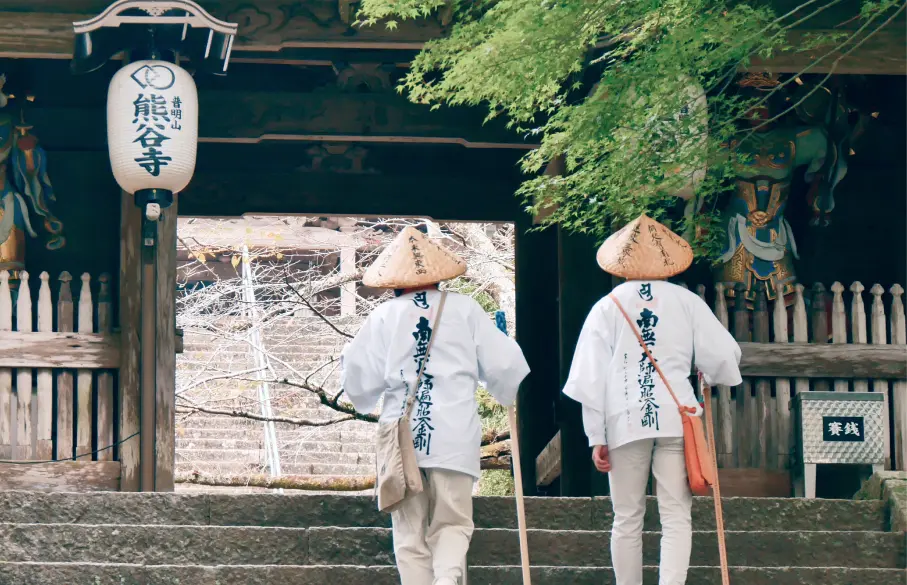Two people climbing the stone steps of the temple